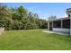 Well-maintained backyard with lush green grass, trees, and a screened-in porch at 2081 Galveston Ave, Deltona, FL 32725