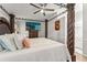 Luxurious bedroom with a statement four-poster bed, ceiling fan, hardwood floors, and a TV at 211 Dalton Dr, Kissimmee, FL 34758