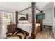 Comfortable primary bedroom with a four-poster bed, hardwood floors, and modern decor at 211 Dalton Dr, Kissimmee, FL 34758