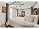 Beautiful bedroom features a statement dark wood four-poster bed, ceiling fan, and neutral walls at 211 Dalton Dr, Kissimmee, FL 34758