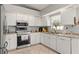 Bright kitchen featuring white cabinets, stainless steel appliances, and granite countertops at 211 Dalton Dr, Kissimmee, FL 34758
