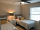 Bright bedroom featuring two twin beds, a ceiling fan, and a table lamp at 222 Georgetown Dr # C, Casselberry, FL 32707