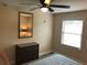 Bedroom showcasing a neutral color scheme, ceiling fan, large mirror, and ample natural light at 222 Georgetown Dr # C, Casselberry, FL 32707