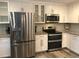 Close-up of a kitchen with stainless steel appliances, white cabinets, and granite countertops, showcasing modern finishes at 222 Georgetown Dr # C, Casselberry, FL 32707