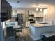 Bright kitchen with white cabinets, stainless steel appliances, and a granite island complemented by a cozy breakfast nook at 222 Georgetown Dr # C, Casselberry, FL 32707