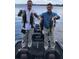 Two men holding up their freshly caught bass fish by the lake at 222 Georgetown Dr # C, Casselberry, FL 32707