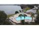 Community swimming pool with palm trees, lounge chairs, and waterfront views at 222 Georgetown Dr # C, Casselberry, FL 32707