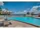 Inviting swimming pool with clear blue water, lounge chairs, umbrellas, and lake views at 222 Georgetown Dr # C, Casselberry, FL 32707