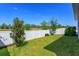 Lush backyard with a white fence providing privacy and plenty of space for outdoor activities and gardening at 2285 Mystic Maze Ln, Clermont, FL 34715
