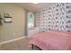 Cozy bedroom with tiled floors, decorative wallpaper, and ample light from the window at 2285 Mystic Maze Ln, Clermont, FL 34715