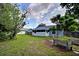 A spacious backyard with green grass, a screened porch, and garden beds at 2516 Albury Ave, Deltona, FL 32738