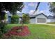 A well maintained lawn and garden compliment this charming one story home with a blue exterior at 2516 Albury Ave, Deltona, FL 32738