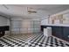 A garage with a black and white checkered floor, garage door, washer, and upper cabinets at 2516 Albury Ave, Deltona, FL 32738