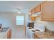 Bright kitchen with tiled flooring, white appliances, and wood cabinets offers ample counter space at 2516 Albury Ave, Deltona, FL 32738