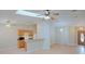 Open-concept living space with hardwood floors, ceiling fans, and a breakfast bar connecting to the kitchen at 2516 Albury Ave, Deltona, FL 32738
