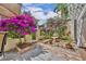 Serene garden featuring vibrant bougainvillea, a stone fountain, and cozy seating area at 264 Balfour Dr, Winter Park, FL 32792