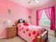 Cozy pink bedroom featuring a double bed and a wooden dresser next to the window at 2781 Almaton Loop # 404, Kissimmee, FL 34747