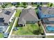 A backyard view showing the lawn, fence, covered porch, and play equipment at 299 Whirlaway Dr, Davenport, FL 33837