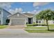Charming single-story home with a brick driveway, manicured landscaping, and a gray stucco exterior at 299 Whirlaway Dr, Davenport, FL 33837