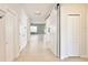Bright hallway featuring neutral tile floors, white trim, and sliding barn doors leading to the living areas at 299 Whirlaway Dr, Davenport, FL 33837