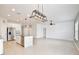 Open-concept living space with a kitchen island, tile flooring, and modern lighting fixtures at 299 Whirlaway Dr, Davenport, FL 33837