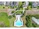 Community pool view from above with manicured grounds, outdoor lounge chairs, and proximity to a pond at 299 Whirlaway Dr, Davenport, FL 33837