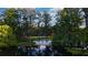 Aerial view of the property featuring a beach, lake, and home nestled among mature trees at 320 Mary Jess Rd, Orlando, FL 32839