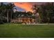Spacious backyard with a swimming pool, lush greenery, and an inviting outdoor lounge area at sunset at 320 Mary Jess Rd, Orlando, FL 32839