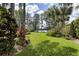 Well-manicured backyard with lush greenery and a glimpse of the lake, showcasing serene outdoor living at 320 Mary Jess Rd, Orlando, FL 32839
