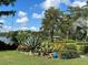 Expansive backyard with lush greenery and decorative landscaping, leading to scenic lake views at 320 Mary Jess Rd, Orlando, FL 32839