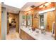Bathroom featuring dual sinks, skylight, and wood accent wall at 320 Mary Jess Rd, Orlando, FL 32839