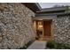 Close up view of the home's entrance with a stone exterior and custom wood door at 320 Mary Jess Rd, Orlando, FL 32839
