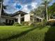 Modern home exterior with lush landscaping, pergola, and large windows, offering a serene outdoor living space at 320 Mary Jess Rd, Orlando, FL 32839