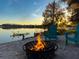 Inviting fire pit scene on the beach with lake view and Adirondack chairs under a picturesque sunset at 320 Mary Jess Rd, Orlando, FL 32839