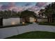 A daytime view of the stone home with mature landscaping, unique exterior lighting, and a driveway at 320 Mary Jess Rd, Orlando, FL 32839
