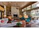 Living room with brick floors, wood ceilings, a stone fireplace, and walls of windows overlooking pool at 320 Mary Jess Rd, Orlando, FL 32839