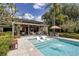 Stunning pool with sun shelf and lounge chairs, covered patio, and lush landscaping, enhancing outdoor living at 320 Mary Jess Rd, Orlando, FL 32839