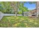Spacious backyard with lush green grass, a privacy fence, a screened patio, and mature trees at 353 Meadow Beauty Ter, Sanford, FL 32771