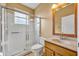 Bright bathroom featuring a tile shower with glass door, wood vanity and sink, plus neutral decor at 353 Meadow Beauty Ter, Sanford, FL 32771