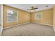 Comfortable bedroom with neutral carpet, ceiling fan, and two bright windows with blinds at 353 Meadow Beauty Ter, Sanford, FL 32771