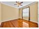 This bedroom features gleaming hardwood floors, neutral walls, a ceiling fan, and a bright window at 353 Meadow Beauty Ter, Sanford, FL 32771