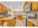 Modern kitchen featuring granite countertops, an island, and stainless steel appliances at 353 Meadow Beauty Ter, Sanford, FL 32771