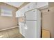 Bright laundry room with tile flooring, washer hookup, white cabinets, and a large refrigerator at 353 Meadow Beauty Ter, Sanford, FL 32771
