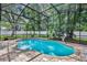 Sparkling screened-in pool with brick patio, landscaping, and a surrounding lush green yard at 353 Meadow Beauty Ter, Sanford, FL 32771