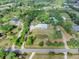 Expansive aerial view of the property with a beautiful pond and a well-manicured lawn at 3550 Kaiser Ave, St Cloud, FL 34772