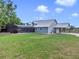 Back of a large blue house with a metal roof, screened in pool area and large yard at 3550 Kaiser Ave, St Cloud, FL 34772