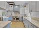 Bright kitchen with white and blue cabinets, stainless steel range and hood, and marble countertops at 3550 Kaiser Ave, St Cloud, FL 34772