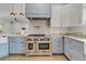 Bright kitchen with white and blue cabinets, stainless steel range, and marble countertops at 3550 Kaiser Ave, St Cloud, FL 34772