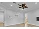 Well-lit room featuring concrete floors, a ceiling fan, and a door that gives access to a kitchen at 3550 Kaiser Ave, St Cloud, FL 34772