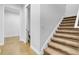 Carpeted staircase with a adjacent door leading to a restroom at 3550 Kaiser Ave, St Cloud, FL 34772